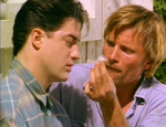 Clay shows off the coin he pulled from behind Darkly's ear. (Viggo Mortensen, Brendan Fraser)